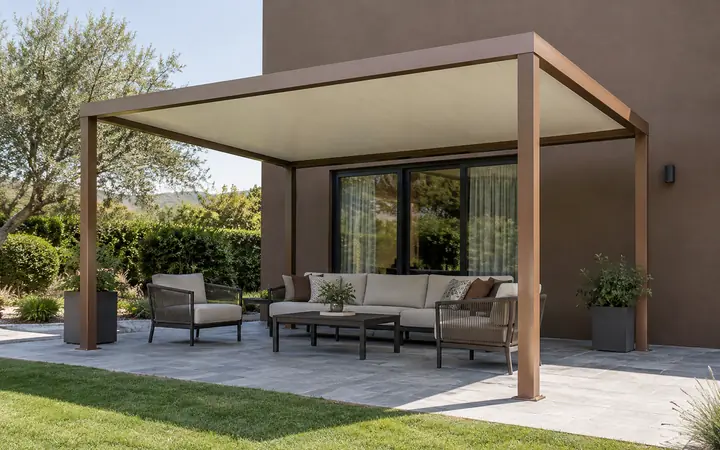Copper-brown freestanding patio cover with a solid cream shed roof over a gray stone seating terrace.
