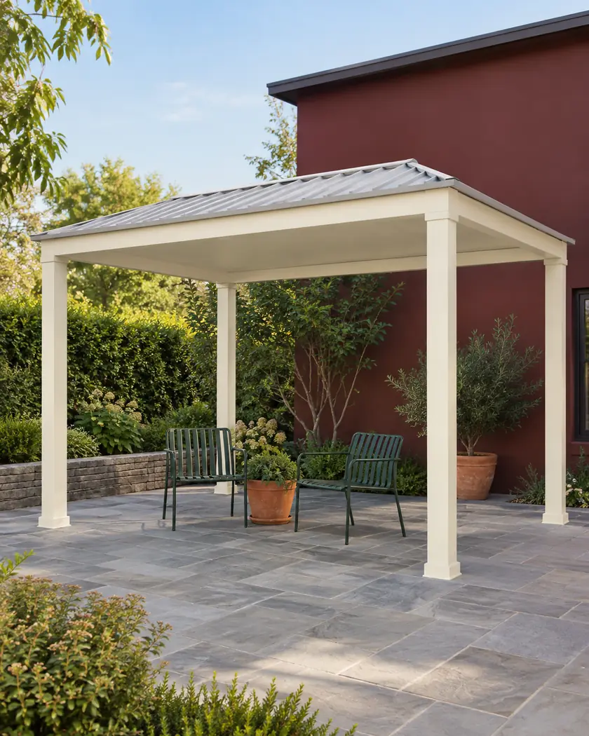 Cream freestanding patio cover with a pale-gray metal roof above green chairs and terracotta pots.