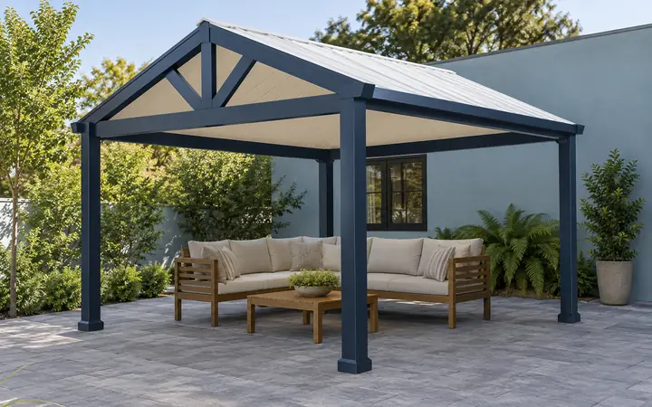 Navy freestanding patio cover with a white gable roof above gray paving and a cedar bench.
